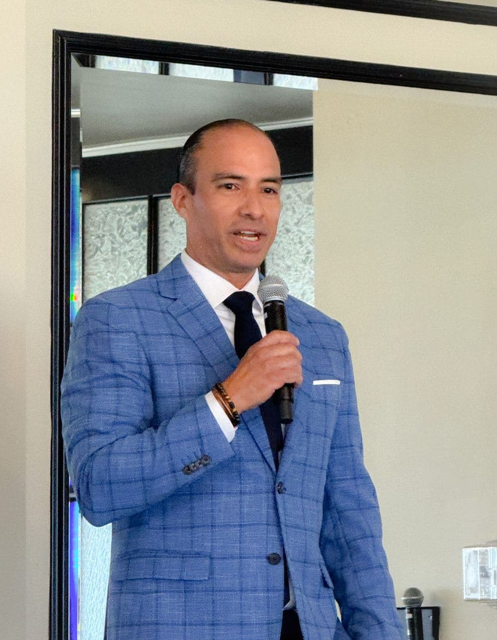 Tayde Aburto speaking with a microphone to a room of business owners